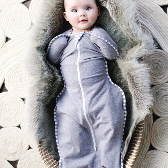 Baby in grijze Love to Dream™ Swaddle Up™ met witte strepen, liggend in een mand.