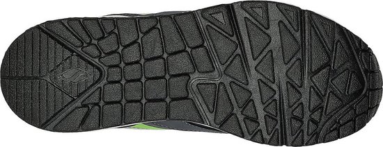 Onderkant van grijze jongens sneaker met zwart profiel en felgroene accenten.