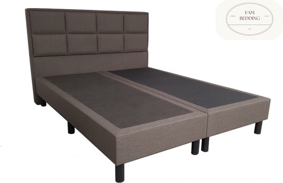 Tweepersoons bruine boxspring met hoofdbord met vierkante kussens en zwarte pootjes.