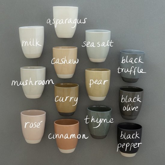 Collectie aardewerk mokken in diverse kleuren en namen zoals melk, peer, curry, en zwart peper.
