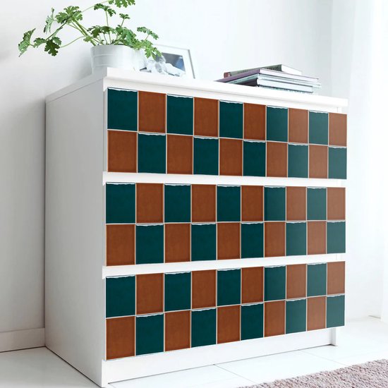 Une commode blanche avec un motif de carreaux carrés marron et verts sur les tiroirs.