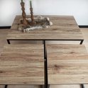 Trois tables basses avec plateau en bois et cadre en métal noir. La plus grande table est au centre.