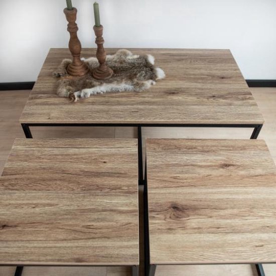 Trois tables basses avec plateau en bois et cadre en métal noir. La plus grande table est au centre.