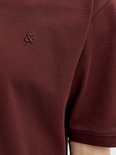 Detail van het geborduurde logo op een donkerbruine polo