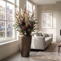 Vase métallique doré avec un bouquet séché d'herbe de pampa, de protea et d'eucalyptus.