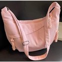 Roze corduroy schoudertas met rits aan de voorkant en verstelbare gesp.