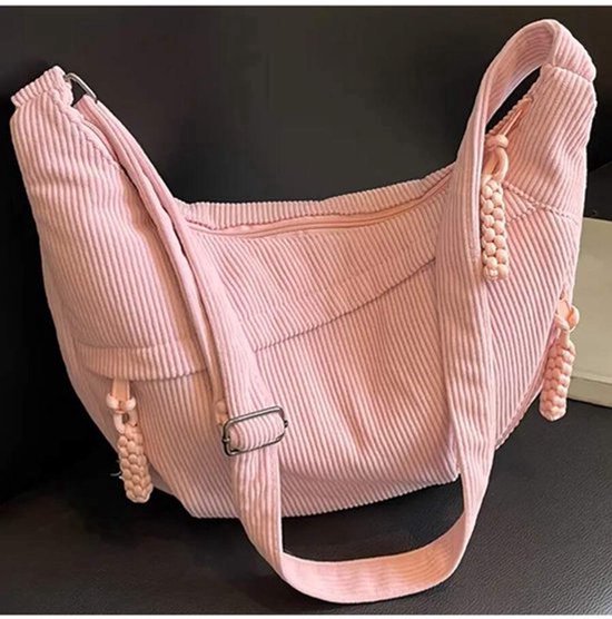 Roze corduroy schoudertas met rits aan de voorkant en verstelbare gesp.