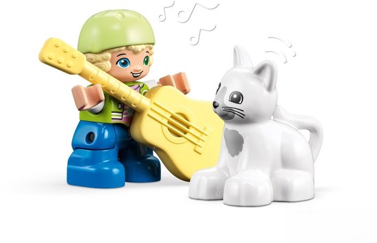 LEGO Duplo jongen met groene pet en gele gitaar naast witte kat.