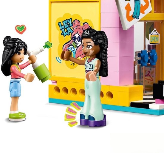 Deux figurines, l'une aux cheveux blonds et l'autre aux cheveux tressés et taches de naissance, tenant un pulvérisateur vert.