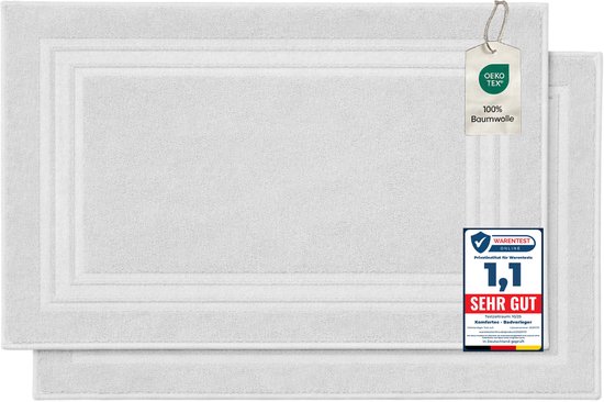Twee witte katoenen badmatten, met OEKO-TEX label en Warentest 'Sehr Gut' keurmerk.