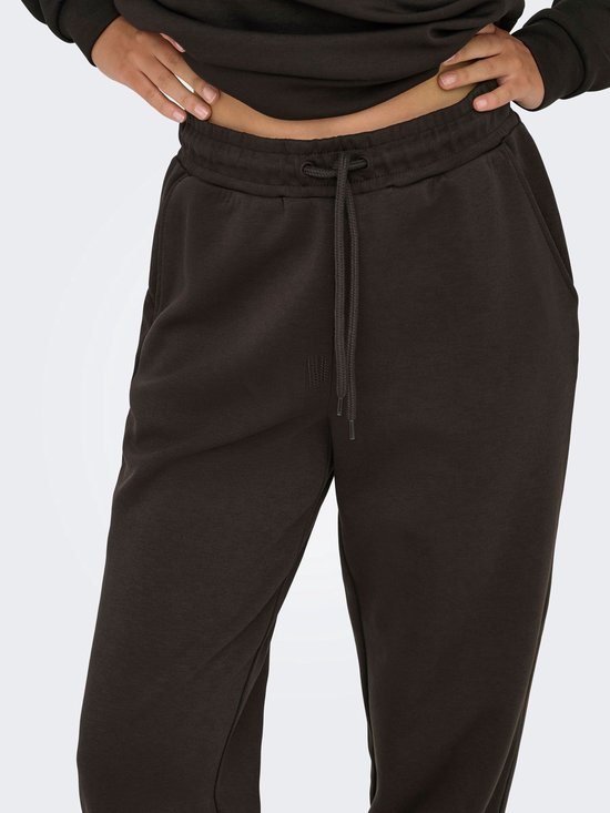 Close-up van een donkerbruine joggingbroek met trekkoord.