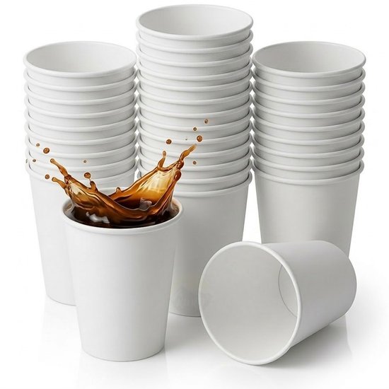 Stapel witte kartonnen bekers. Een beker in de voorgrond heeft koffie met een spat.