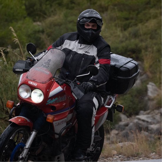 Man op rode Yamaha motor, met zwarte helm en DXR motorjas.