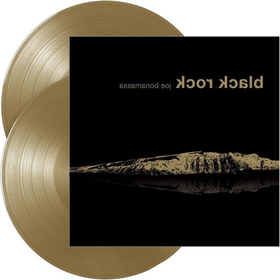 Twee gouden vinylplaten naast een albumhoes met een zwarte achtergrond, goudkleurige bergen en de tekst 'Black Rock'.