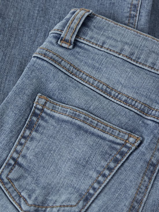 Detail van de achterzak van een blauwe spijkerbroek.