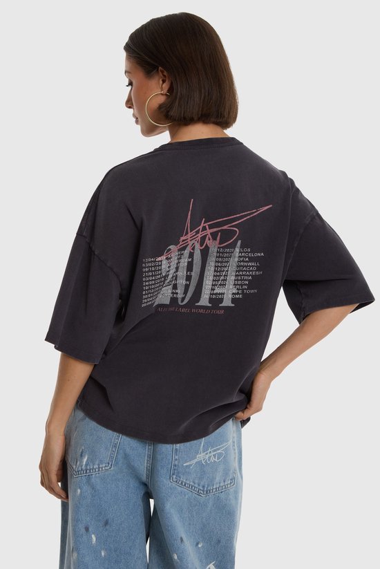 Model draagt zwart T-shirt met '2014 World Tour' print op de achterkant en tekst van tourdata.