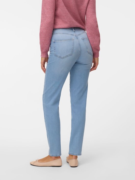Model van achteren in lichtblauwe mom fit jeans, gedragen met een roze vest en ballerina's.