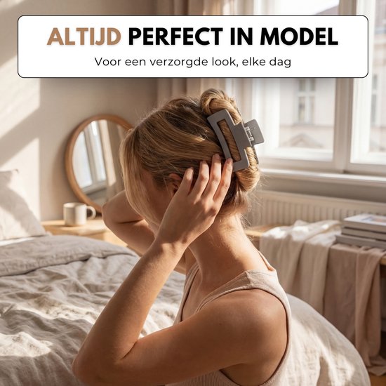 Vrouw met blond haar die een grijze haarklem in haar opgestoken haar plaatst in een slaapkamer.