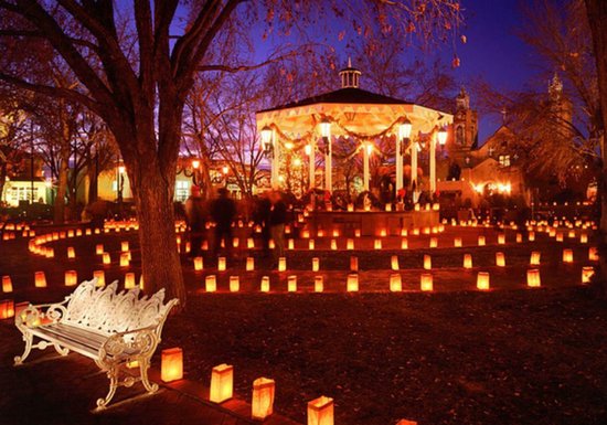 Gazebo en omgeving met lantaarns bij nacht, mensen lopen rond.