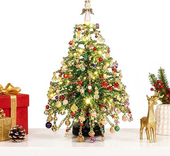 Een volledig versierde kerstboom van kralen met lampjes en een engel erop, tentoongesteld met kerstcadeaus en decoraties.