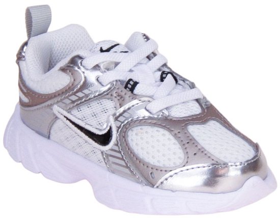 Witte Nike sneaker met zilveren accenten, vetersluiting en een zwarte swoosh.