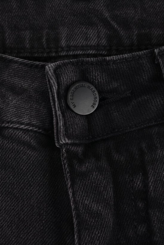 Detail van de knoopsluiting van een zwarte spijkerbroek met de tekst "MY ESSENTIAL WARDROBE".
