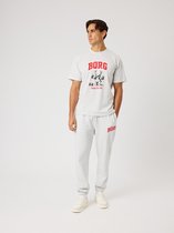 Man met grijze joggingbroek met 'BORG' logo en grijs T-shirt met beer-print en tekst 'TRAIN TO LIVE'.
