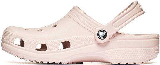 Zij-aanzicht van een lichte roze Crocs clog met de band naar achteren. De schoen heeft perforaties aan de bovenkant.