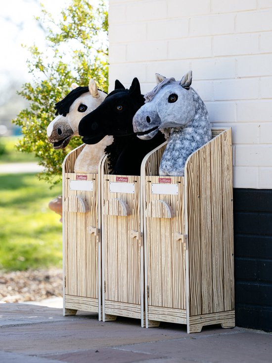 Drie hobbyhorse stallen met een houten print. De stallen bevatten een wit, zwart en grijs gevlekt hobbyhorse, elk met een rozet.