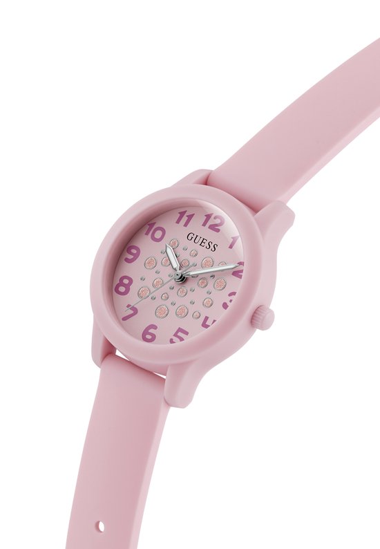 Close-up van een lichtroze Guess horloge met roze glitterstippen op de wijzerplaat.