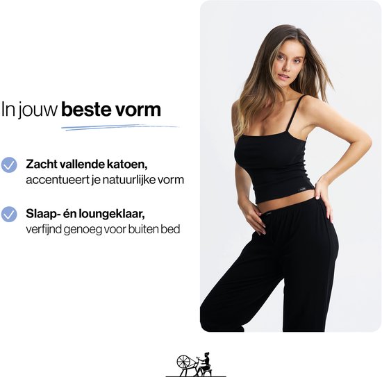 Model in zwarte pyjama, handen op de heupen. Links: tekst 'In jouw beste vorm', 'Zacht vallende katoen' en 'Slaap- én loungeklaar'.