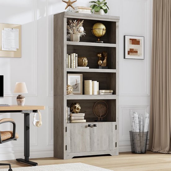 Hoge grijze boekenkast met 5 open planken, 2 deuren onderaan, gedecoreerd met boeken en ornamenten.