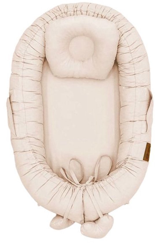 Zandkleurig babynestje van MorDesign met een rond kussentje en verstelbare bandjes.