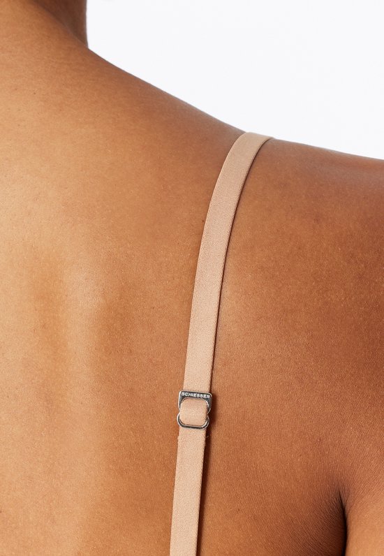 Detail van een verstelbaar bandje van een beige, naadloze beugel-vrije bh met Schiesser-logo.
