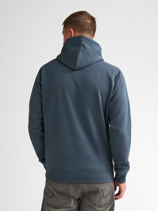 Man van achteren gezien in een blauwe hoodie met capuchon en grijze jeans.
