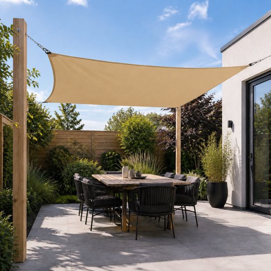 Een beige rechthoekig schaduwdoek hangt boven een tuintafel met stoelen.