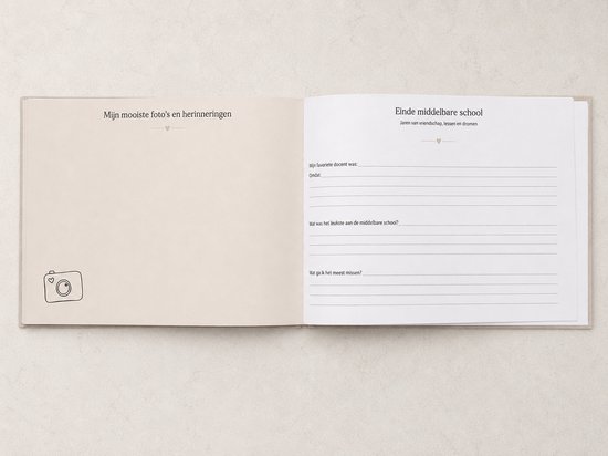 Een open boek met lichtbeige pagina's. Links staat 'Mijn mooiste foto's en herinneringen' met een camera-icoon. Rechts zijn invulvelden met de titel 'Einde middelbare school'.