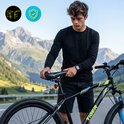 Man staat naast een zwarte TIGER MTB-fiets met blauwe voorvork en bergen op de achtergrond.