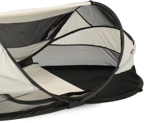 Gedetailleerde kijk op de opening van het Deryan Baby Luxe campingbedje, met crème stof en zwart gaas.