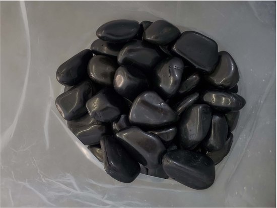 Zwarte, glanzende kiezels in een plastic zak, gezien van bovenaf.