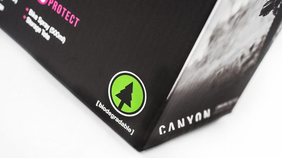Detail van een zwarte doos met een groen biodegradabel icoon en de tekst 'CANYON'.