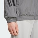 Detail van de zoom en mouw van een grijs Adidas trainingsjack met zwarte 3-strepen.