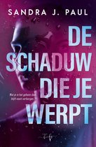 Boekomslag van De schaduw die je werpt door Sandra J. Paul met een persoonlijk gezicht achter regendruppels in paars licht.