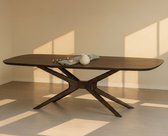 Donkerhouten eettafel met een organisch gevormd blad en een gedraaide poot, in een kamer met houten vloer.