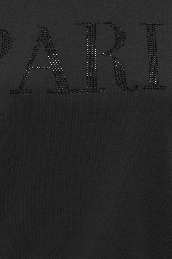 Detail van de "PARIS" opdruk van zwarte parels op een zwarte sweater.