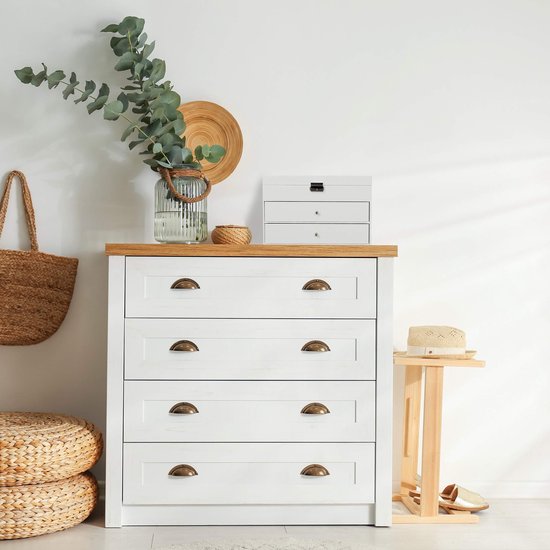 Witte lader met houten blad, vier lades met metalen knoppen, naast een rieten mand en een bijzettafel.