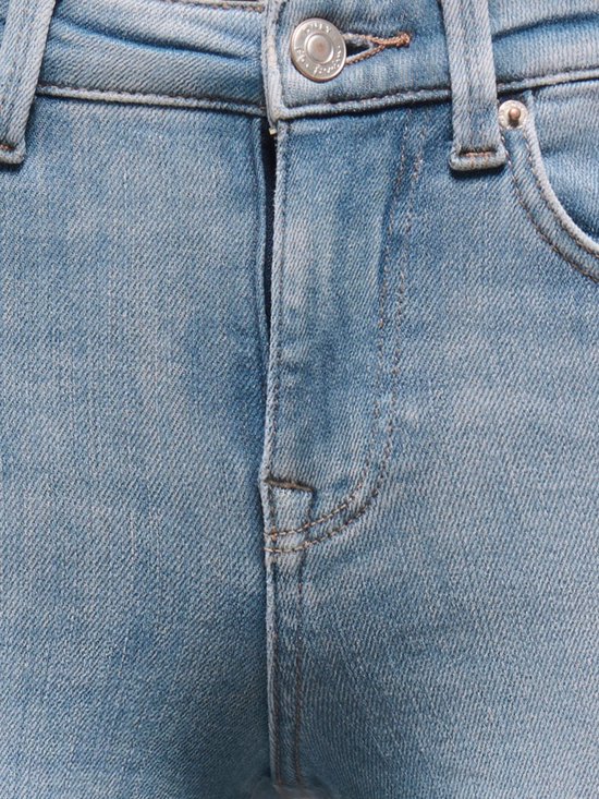 Gedetailleerde close-up van de knoop en ritssluiting van een lichtblauwe jeans.