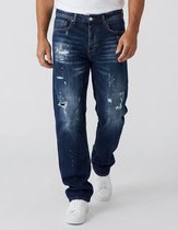 Man in donkerblauwe baggy jeans met distressed details en lichte wassing.