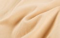 Een close-up van zacht, beige gebreide stof.