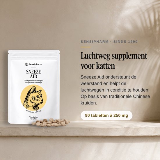 Een witte zak met "Sneeze Aid" en een tekening van een kattenkop. Naast de zak liggen bruine tabletten. Tekst links: Luchtweg supplement voor katten. Sinds 1990.